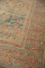 Worn Herati field meets the sky blue samovar border of this antique Sultanabad carpet.