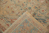 Distressed antique Sultanabad carpet corner showing worn field, blue border, and visible foundation.