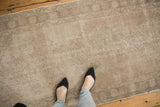 Hand-knotted distressed Oushak runner with faded floral medallions in soft blush, ivory, beige.