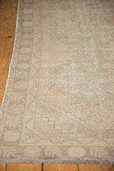 Distressed Oushak runner, secured side and faded Rococo floral patterns in pale blush and beige.
