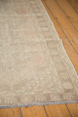 Secured side and distressed pile of vintage Oushak runner in muted blush and ivory.