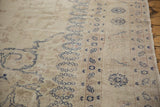 Scrolling navy arabesques and border details on the low, time-softened pile of a vintage Sparta carpet.