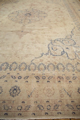 Detailed view of a vintage Sparta carpet's distressed wear, showing the foundation and scrolling navy patterns.