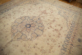 A view over the distressed floral field and roundel medallion of a vintage Sparta carpet.