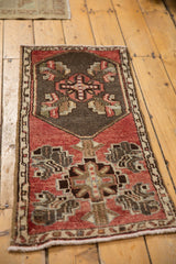 Distressed Oushak rug's original side selvage and narrow seed-and-vine border in dusty blush.