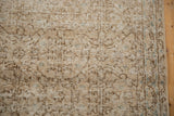 Distressed vintage Sparta runner detail: scrolling vinery, blue blossoms, and even pile wear.