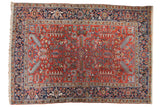 Vintage Heriz carpet with cherry red field, geometric floral design, and navy turtle main border.