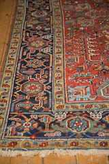 Vintage Heriz carpet corner: cherry red field, navy border, geometric turtle motifs.