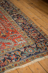 Vintage Heriz: cherry red field, navy border, classic turtle motifs, low pile, and fringe.