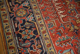 Close-up of vintage Heriz rug's geometric floral field and classic turtle border motif.