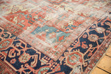Vintage Heriz rug corner with navy samovar turtle border and visible knot heads.