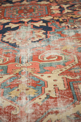 Vintage Heriz rug's traditional red, navy, ivory pattern with visible foundation wear.