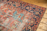 Worn brick red and light blue field of a vintage Heriz rug, with navy border.