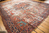 Vintage Heriz carpet corner: navy blue samovar border and storied pile texture.