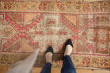 Distressed Oushak runner detail revealing geometric pomegranate and hook motifs in blush, saffron, ivory.