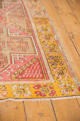 Distressed vintage Oushak rug with a bright saffron yellow border and geometric blush designs.