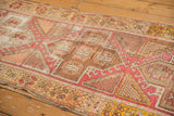 Blush, saffron, and ivory geometric patterns on a distressed vintage Oushak rug.