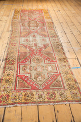 Distressed texture on the secured fringe and saffron yellow border of a vintage Oushak runner.
