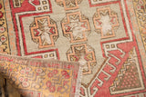 Distressed Vintage Oushak rug corner shows geometric blush, saffron pile wear and hand-knotted reverse.