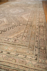 Distressed Khotan carpet with worn patina, featuring beige, pale rose, and blue floral-geometric patterns.