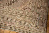 Worn geometric borders of a distressed Vintage Khotan carpet in soft rose and beige.