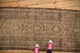 Antique Northwest Persian runner showing geometric border, intricate blossoms, and visible wear.
