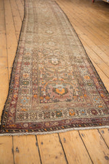 Antique Northwest Persian runner's traditional floral borders and field in aubergine, tangerine, and ivory.