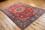 Vintage Northwest Persian rug corner with aqua blue floral border, cherry red field, and fringe.