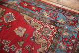 Northwest Persian rug: cherry red floral field, aqua blue trefoil border detail.