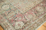 Distressed Tabriz carpet close-up with faded aqua, blush, and ivory intricate motifs.