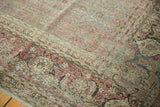 Distressed vintage Tabriz carpet corner with aqua green, cochineal, and ivory patterns.