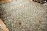 Intricate faded motif in aqua, ivory, and blush on a distressed vintage Tabriz rug.