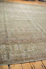 Angled detail of distressed Tabriz rug, revealing intricate aqua green border and foundation wear.