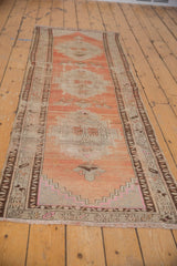 Stepped geometric medallion on an abrashed peach field, highlighting designer-aligned distressed wear.