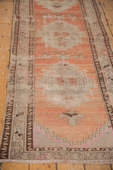Distressed vintage Oushak runner, abrashed peach and ivory field, geometric pattern, prominent wear.