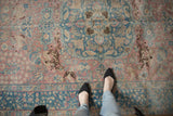 Vintage distressed Tabriz carpet with faded blush, ocean blue, and leopard field motifs.