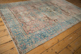 Distressed blush and ocean blue Tabriz carpet with visible leopards and millefleur motifs.