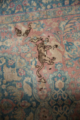 Distressed vintage Tabriz detail showing dark leopard motif, blush, and ocean blue tones.