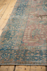 Distressed ocean blue and dusty rose floral border of a vintage Tabriz carpet.