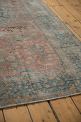 Textured surface of a vintage distressed Tabriz carpet with faded blush and ocean blue.
