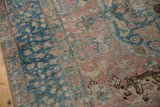 Distressed Persian Tabriz carpet detail showcasing blush, ocean blue, and beige, with leopard motif.