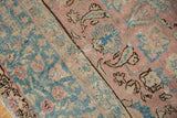 Textured blush, ocean blue, and beige floral patterns of a distressed vintage Tabriz carpet.