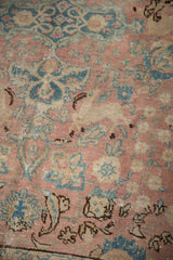 Distressed blush, ocean blue, and sand floral motifs with even wear on a vintage Tabriz carpet.
