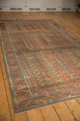The germinating tree of life motif repeating in panels down the length of a vintage Belouch carpet.