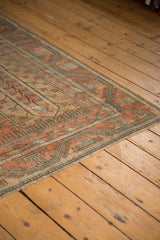 Secured edge and meandering geometric border on a distressed vintage Persian Belouch carpet.