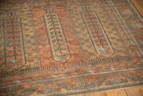 Angled detail of the distressed vintage Belouch carpet's even wear and paneled tree of life motifs.