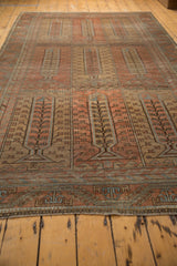 The evenly worn pile of a vintage Belouch carpet showing its terra cotta tree of life design.
