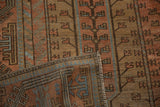 Folded corner of a distressed Belouch carpet reveals its secured side and even, low pile.