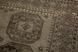 Distressed Ersari carpet detail with oversized floral gul motif in charcoal and oxidized silver.