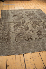 Secured end of the vintage distressed Ersari carpet with even pile wear and silver hues.